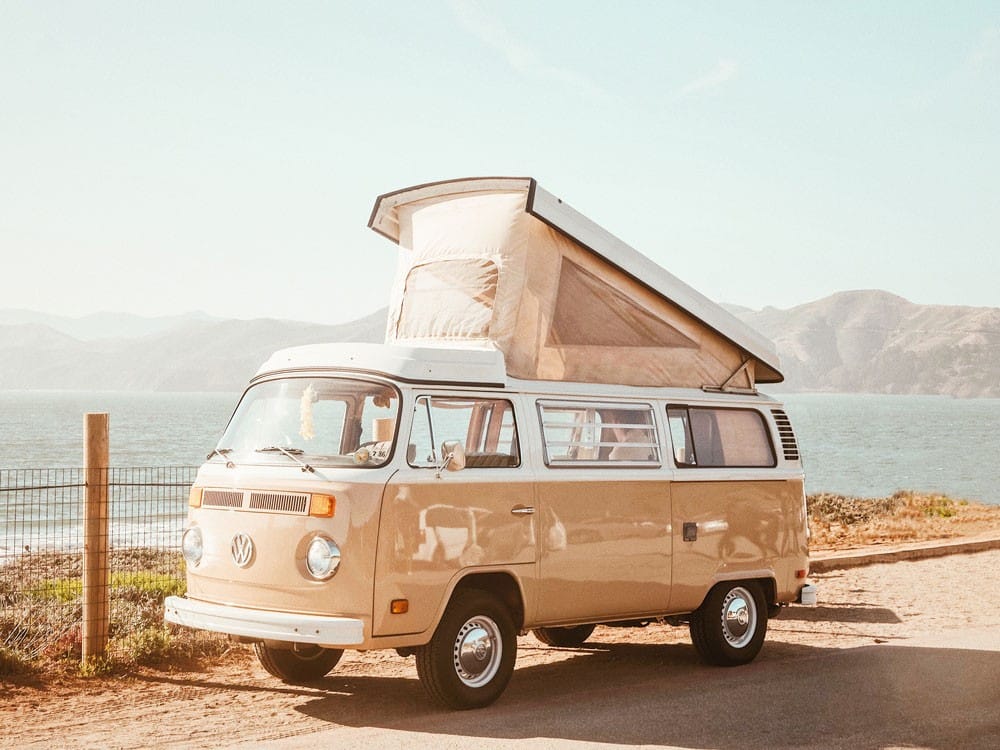 La REGO Australia fotografía de una VAN beige aparcada y detrás la playa